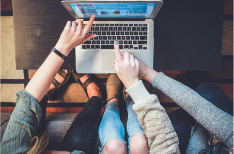 Three people looking at a laptop